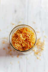 Healthy calendula flowers in a glass vase. Herbal medicine. Dry marigold