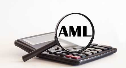 Focused on AML concept. Magnifier glass with text on calculator. Business