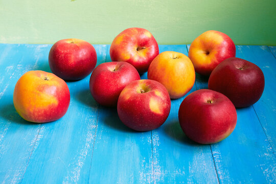 Bright red and yellow apples on a blue background.