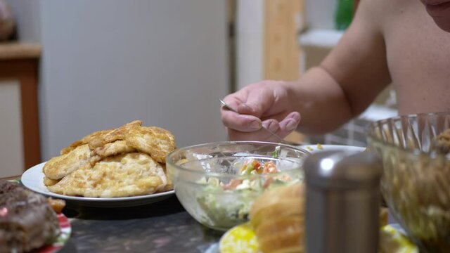 Hungry Man after Working Day Eating Pilaf in Home Kitchen. In Hand Fork. Dinner