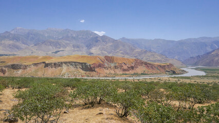 Colorful view on the Panj river valley marking the border with Afghanistan with pistachio trees in the foreground, Darvaz district, Gorno-Badakshan, the Pamir region of Tajikistan