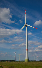 wind turbine in the wind before blue cloudy sky