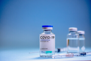 Covid19 Vaccine syringes and medicine bottles in blue environment