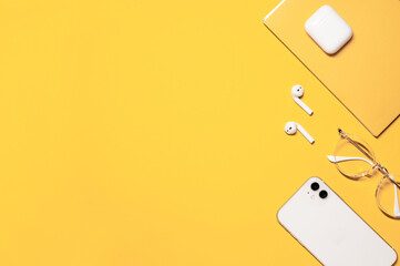 Flat lay photo with a copy space on the left side, and objects on the right: white smartphone,...