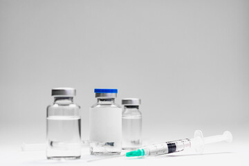 Medical treatment syringes and vaccine bottles in white environment 