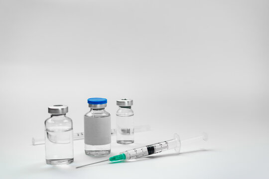 Medical treatment syringes and vaccine bottles in white environment 