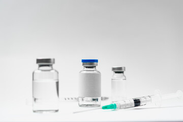 Medical treatment syringes and vaccine bottles in white environment 