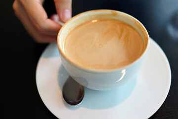 Coffee to go. Fresh latte in a cup on a wooden table in a cafe.