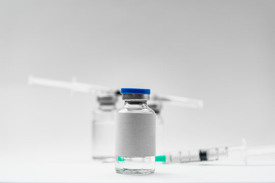 Medical treatment syringes and vaccine bottles in white environment 
