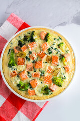 Kish lauren. The pie is open. Quiche Lauren with salmon, spinach and broccoli. Homemade quiche. Classic salmon and broccoli shortcrust pastry pie with broccoli inflorescences in a creamy sauce
