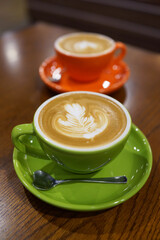 Coffee to go. Fresh latte in a cup on a wooden table in a cafe.