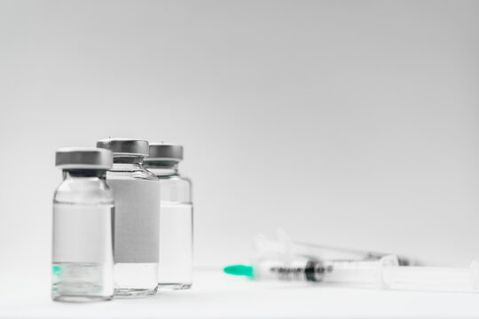 Medical treatment syringes and vaccine bottles in white environment 