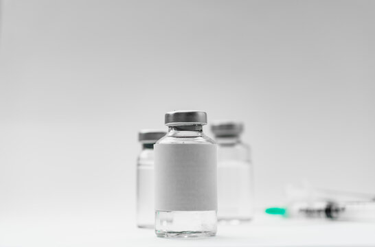 Medical treatment syringes and vaccine bottles in white environment 