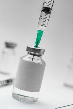 Medical treatment syringes and vaccine bottles in white environment 