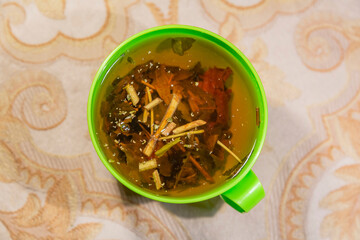 Mix of dried herbs, leaves and stems boiled in a green plastic cup