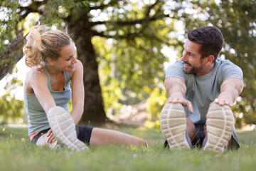Naklejka na ściany i meble happy sporty couple stretching outdoors in park