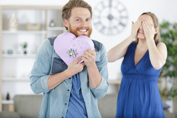 excited man holding gift for pregnant woman