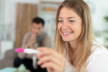 young family with pregnancy test results