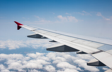 Fototapeta na wymiar Aircraft is flying in blue cloudy sky.