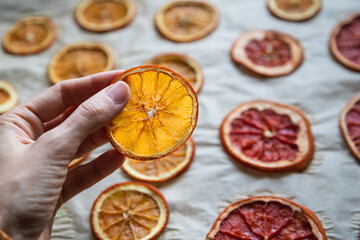 dried orange slice in a hand for diy projects, gift wrapping and beautiful eco Christmas decorations like wreaths - 400345874