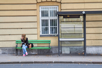 Young caucasian woman waiting for a public transportation on a station.