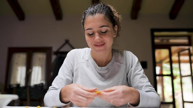 Cheerful woman cooking tortellini at home