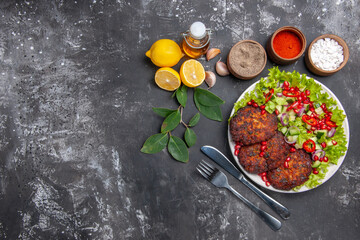 Fototapeta na wymiar top view tasty meat cutlets with vegetable salad on grey desk photo food meal dish