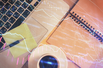 Stock market graph and top view computer on the table background. Double exposure. Concept of financial education.