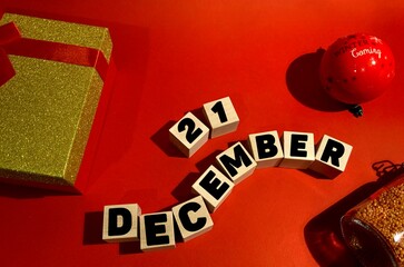 December 21 on wooden cubes .Gift box on a red background.The first month of winter.Calendar for...