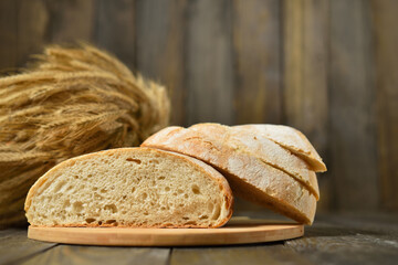 Sliced fresh bread on a wooden wall background