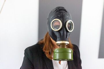 woman working on a computer in the office, business woman in a suit with gas mask because of corona, virus free office woman wearing a soviet gas helmet; 
decontamination staff in office; hacker