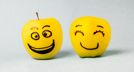 different emotions of joy, smile and happiness Face on an apple - abstract image of human emotions on blue background
