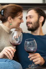 Young and happy couple drinking wine and relaxing at home