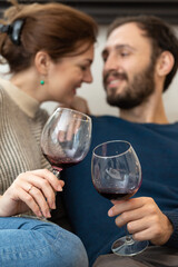Young and happy couple drinking wine and relaxing at home