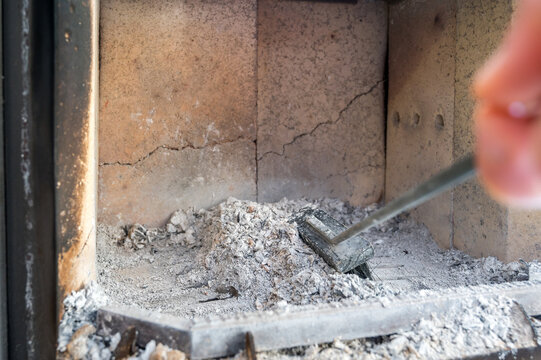 Beseitigung der Asche in einem Kamin mit einem Besen
