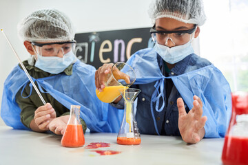 Children in protective masks and gowns pouring chemical liquids