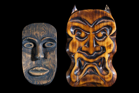 Masks carved from wood on a black background. African mask and the mask trait