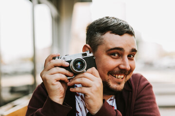 Portrait of a man with a retro camera