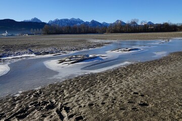 Der entleerte Stausee Forggensee im Allgäuer Alpenvorland 