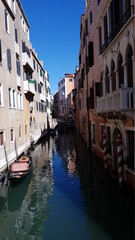 Fototapeta na wymiar Beautiful narrow canal with silky water in Venice, Italy