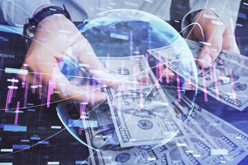 Multi exposure of financial graph drawing hologram and USA dollars bills and man hands. Analysis concept.