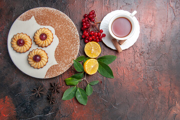 Obraz na płótnie Canvas top view little cookies with tea on dark background biscuit cake sweet