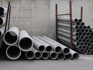 Asbestos-cement pipes of different sizes and diameters for sewage systems, engineering works and wells for sale in a warehouse. Concrete products for construction