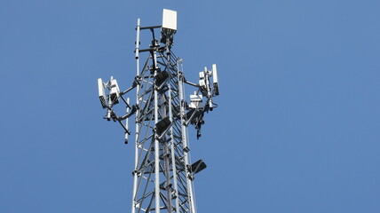 Cell tower antenna soars into blue sky