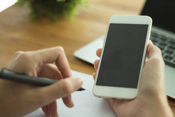 Close up of women's hands holding cell telephone with blank copy space scree for your advertising text message or promotional content