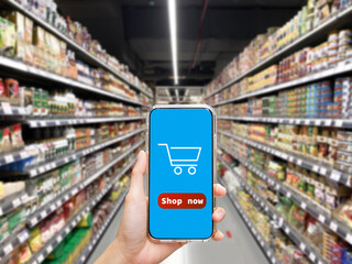 Woman holding smartphone at supermarket with blur background, shopping concept, technology concept.