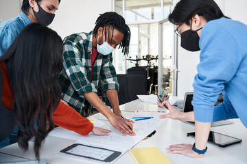 Designers creating mobile app templates are drawn on paper