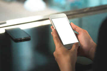 woman hold mockup white smartphone with blurred background. For Graphic display montage., blured backdrop