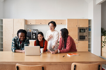 Multiethnic diverse students sitting at the desk and working together at school project