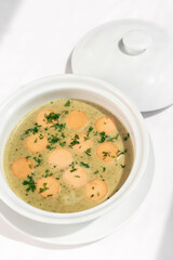German traditional KARTOFFELSUPPE potato and sausage soup on white background